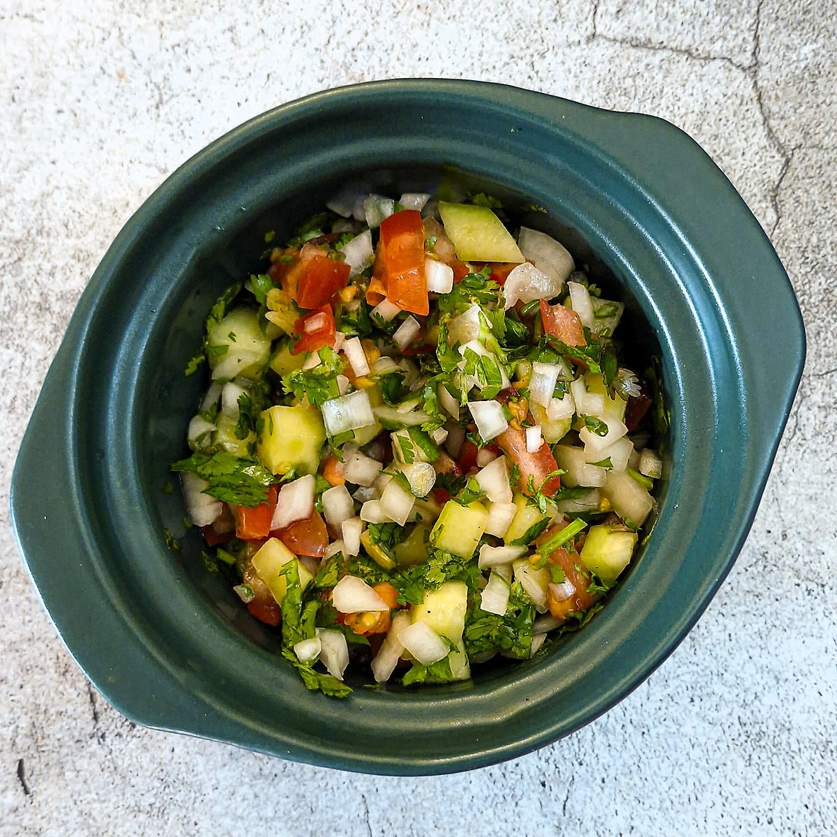 A small green dish of kachumber salad.