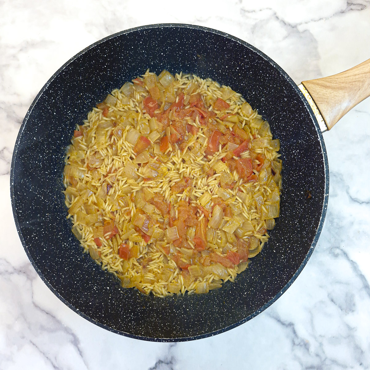 A pan of half-cooked pilaf before the fish is added.