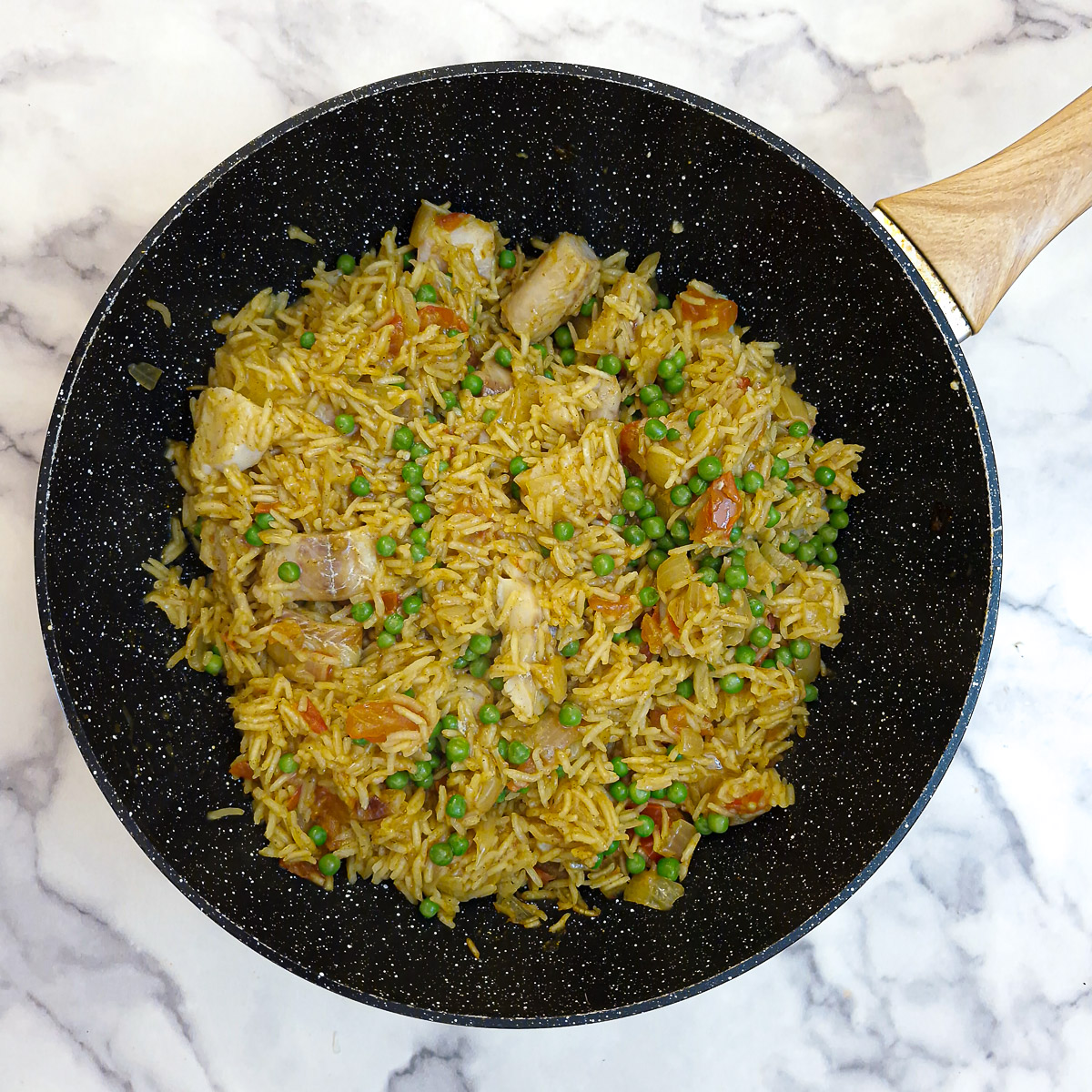 Cooked fish and rice pilaf, with peas folded through.