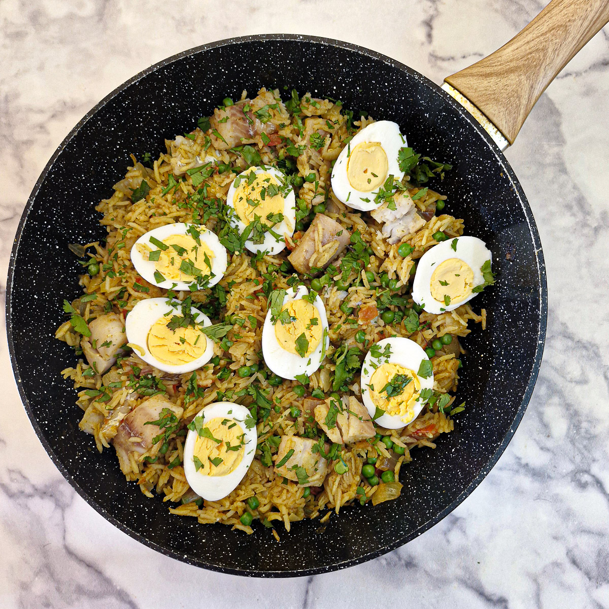 The finished pilaf topped with hard-boiled eggs and garnished with chopped coriander.