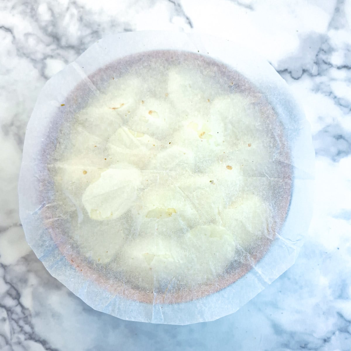 Baking parchments cut into a round cartouche and placed over the layer of potatoes in the casserole dish. This is to keep the steam in.