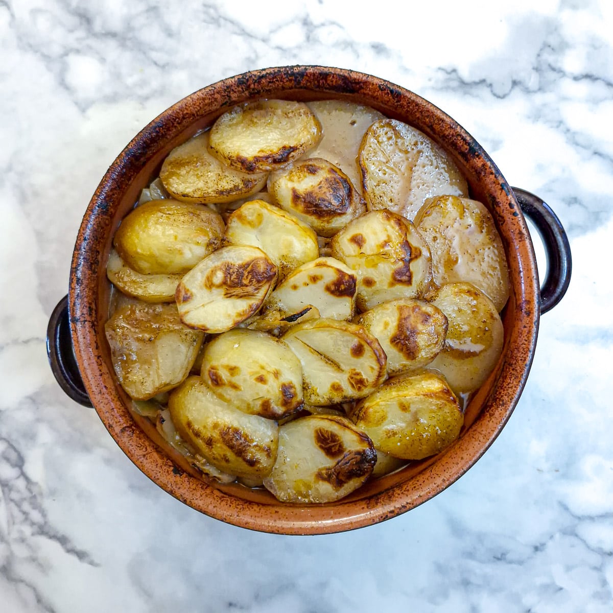 The finished lamb potjie with a layer of browned potatoes. It looks a lot more appetising!