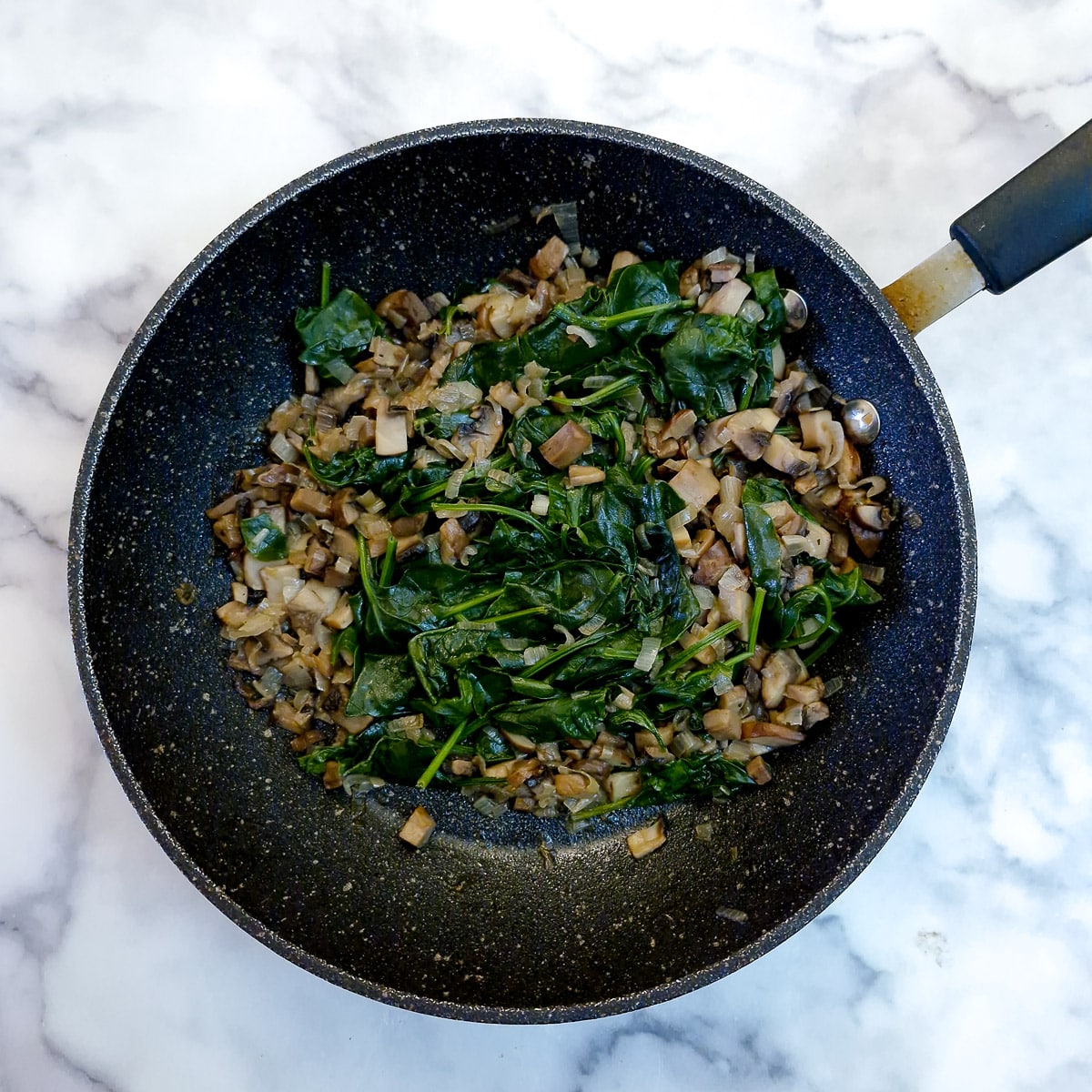Step 5 - spinach in the pan after it has wilted.