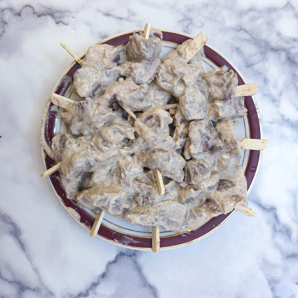 Cubes of marinated lamb threaqded onto short skewers.