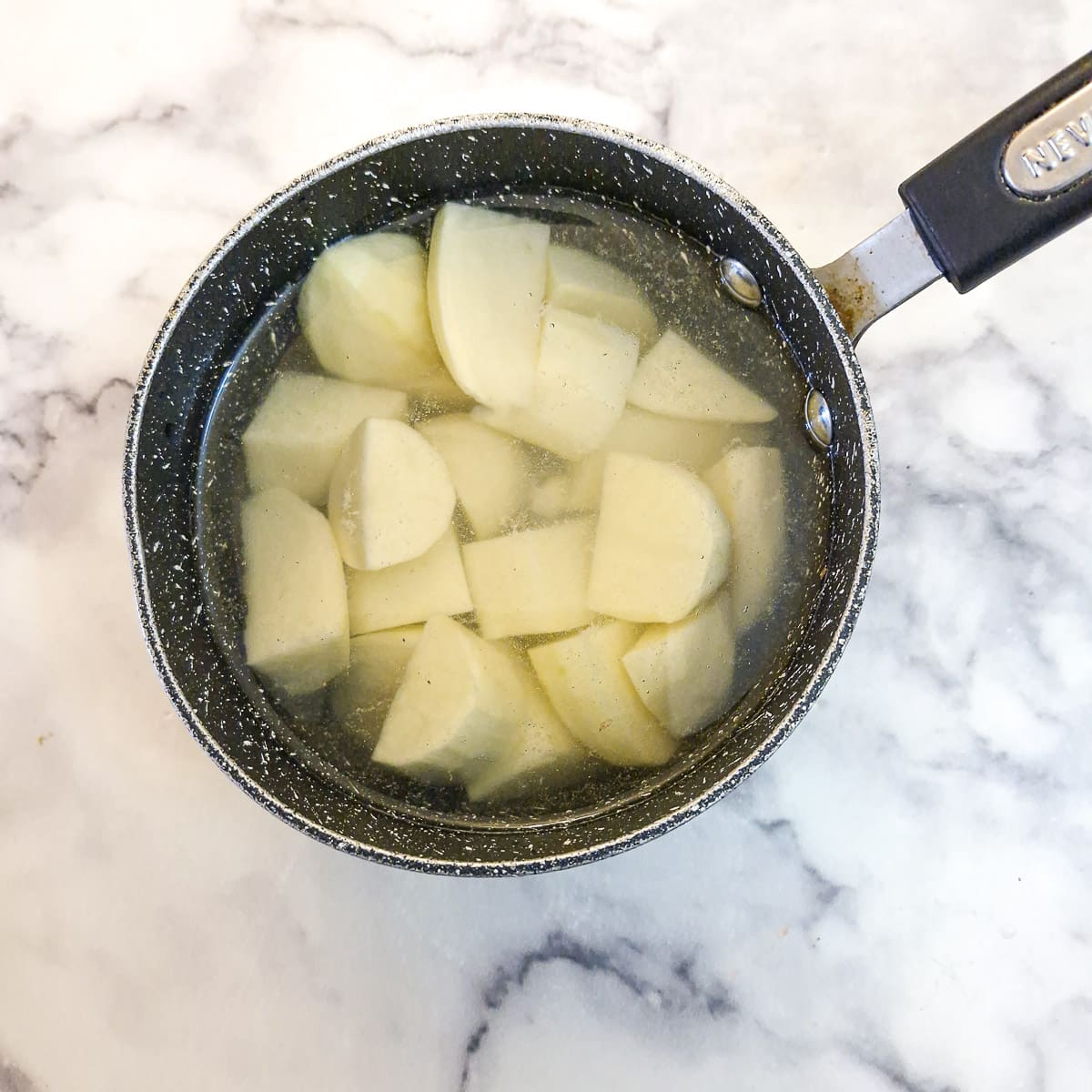 Potatoes in a pan of water ready to boil.
