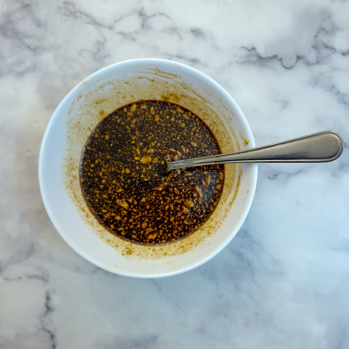 A small white dish of maple syrup glaze.