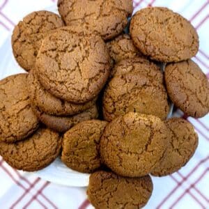 A pile of crispy ginger snaps on a plate.