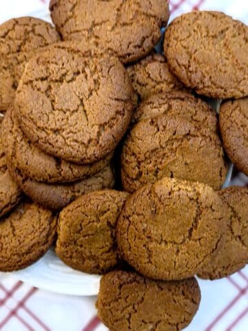A pile of crispy ginger snaps on a plate.