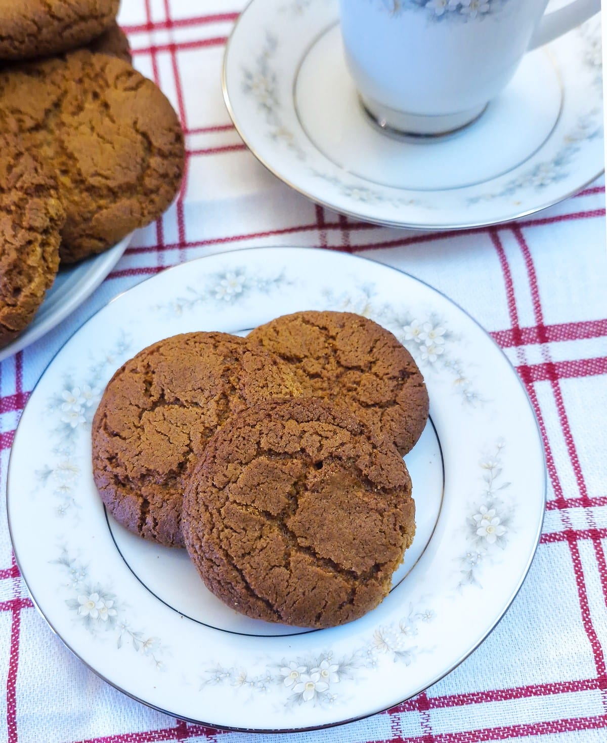 Close up of three ginger snap biscuits on a cake plate.