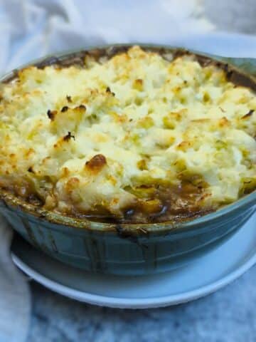 Colcannon-topped sausage bake in a green casserole dish.