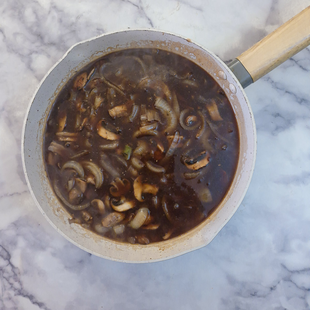Step 10 - gravy granules dissolved in boiling water and poured over the mushrooms and onions.