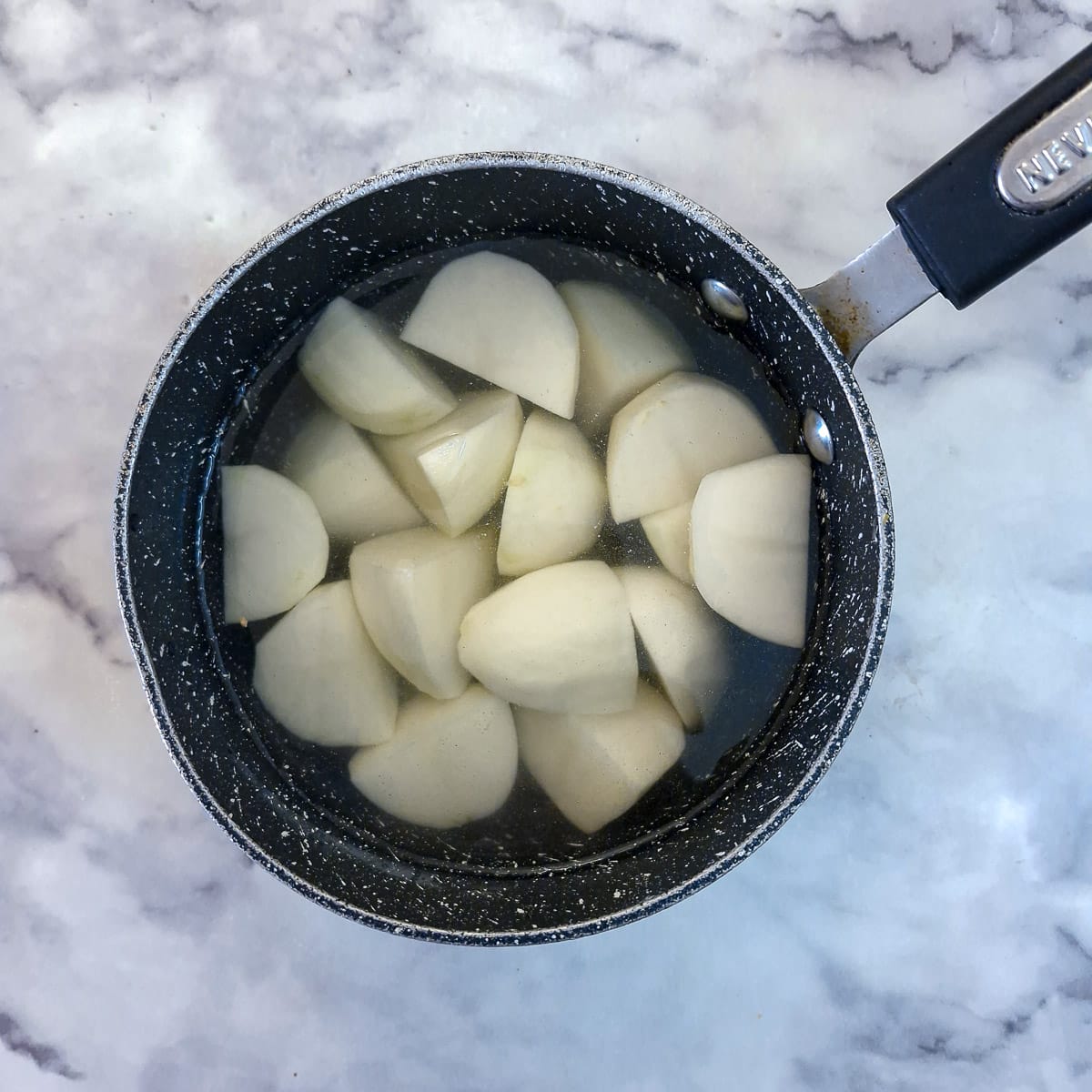 Step 1 - chunks of potatoes in a pan of salted water.
