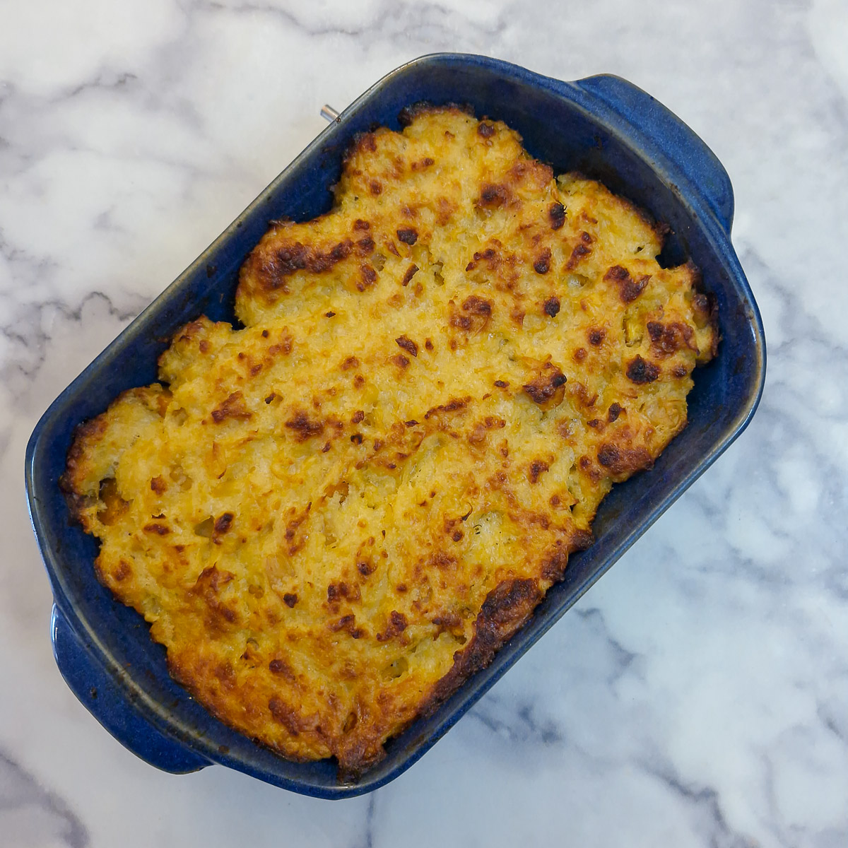 A dish of baked butternut and corn casserole.