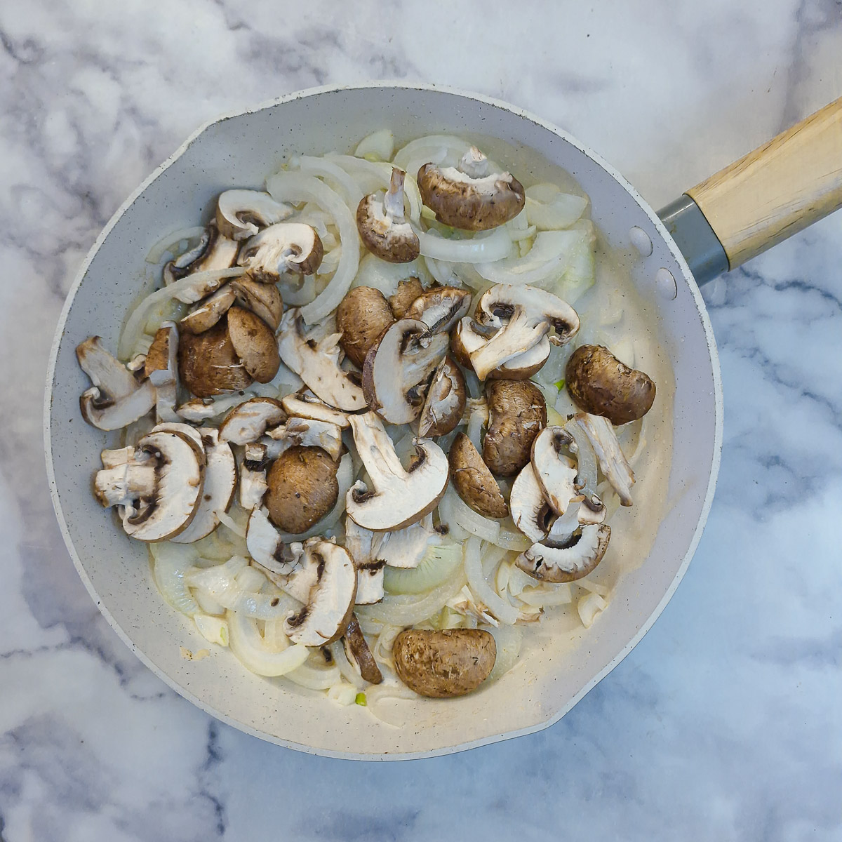 Step 8 - sliced onions and mushrooms in a frying pan.