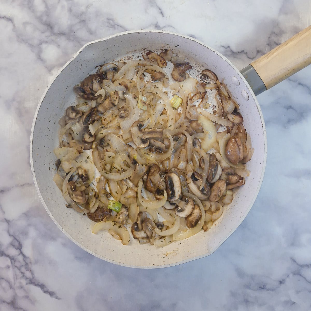 Step 9 - sliced mushrooms and onions softened in a frying pan.