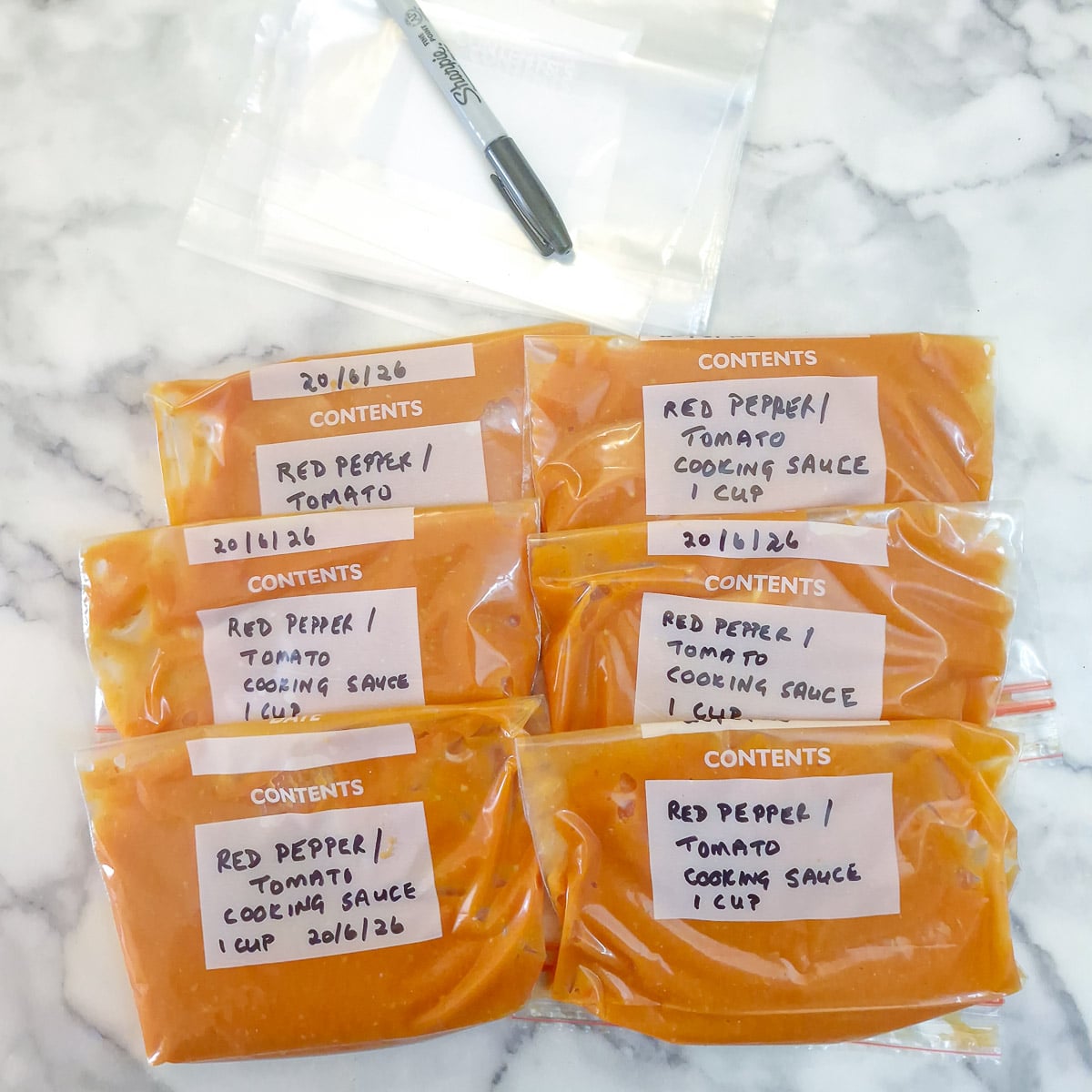 6 freezer bags of tomato cooking sauce labelled and ready for the freezer.