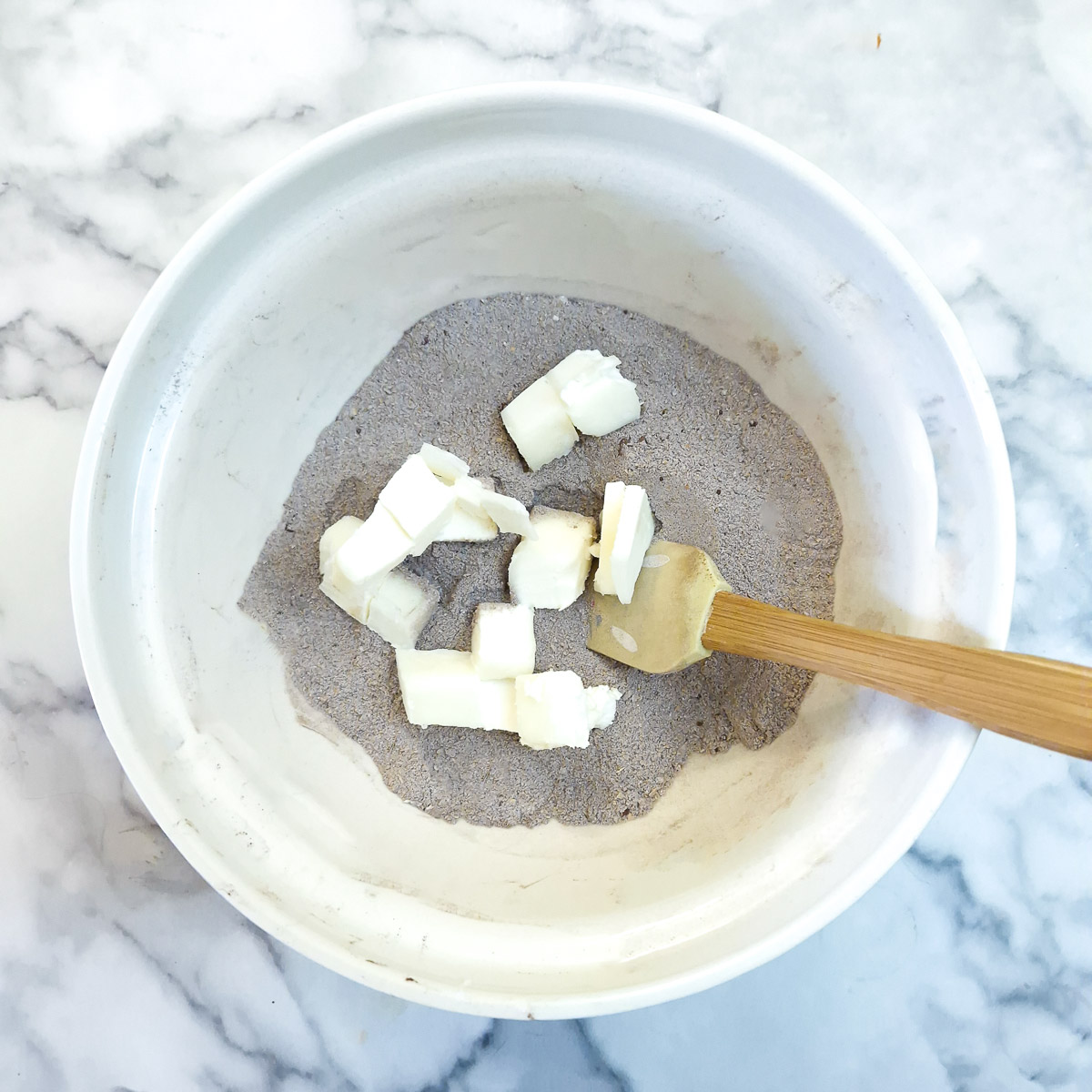 Cubes of margarine added to the dry ingredients.