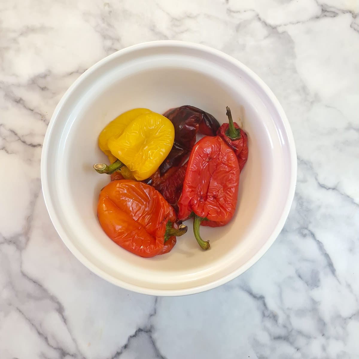 Roasted peppers in a dish, ready to be covered with a plate
and left to steam.
