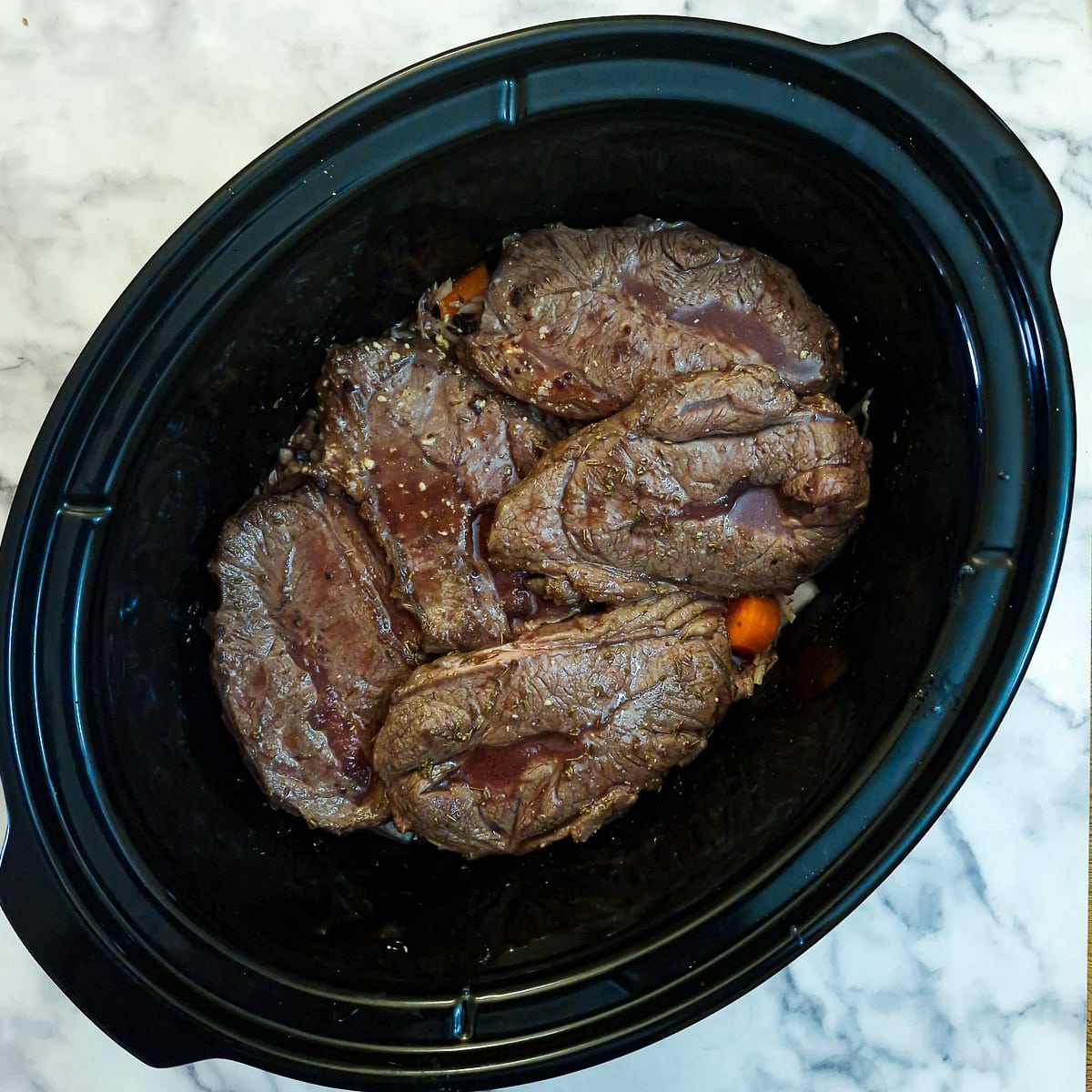 A mixture of stock, red wine and flavourings poured over the ingredients in the slow cooker.