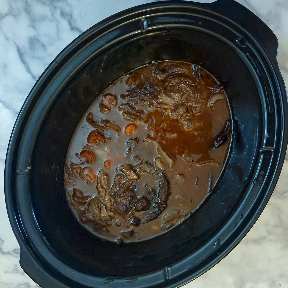 Cooked stewing steak in the slow cooker. There is a lot of gravy.
