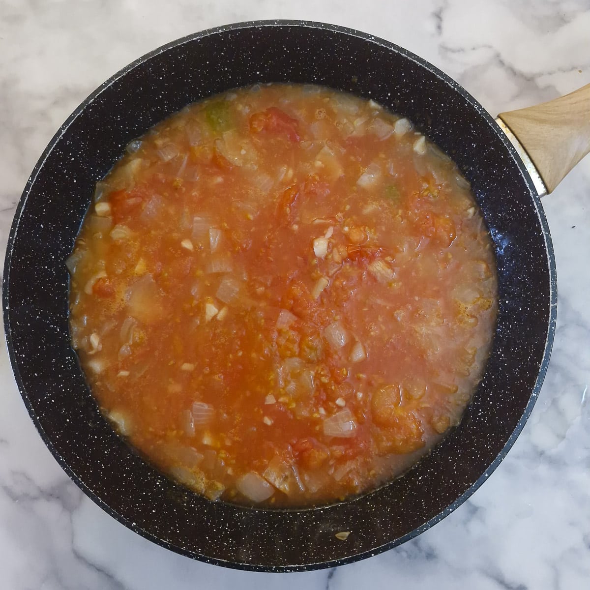 Step 7 - skinned tomatoes added to the onions.