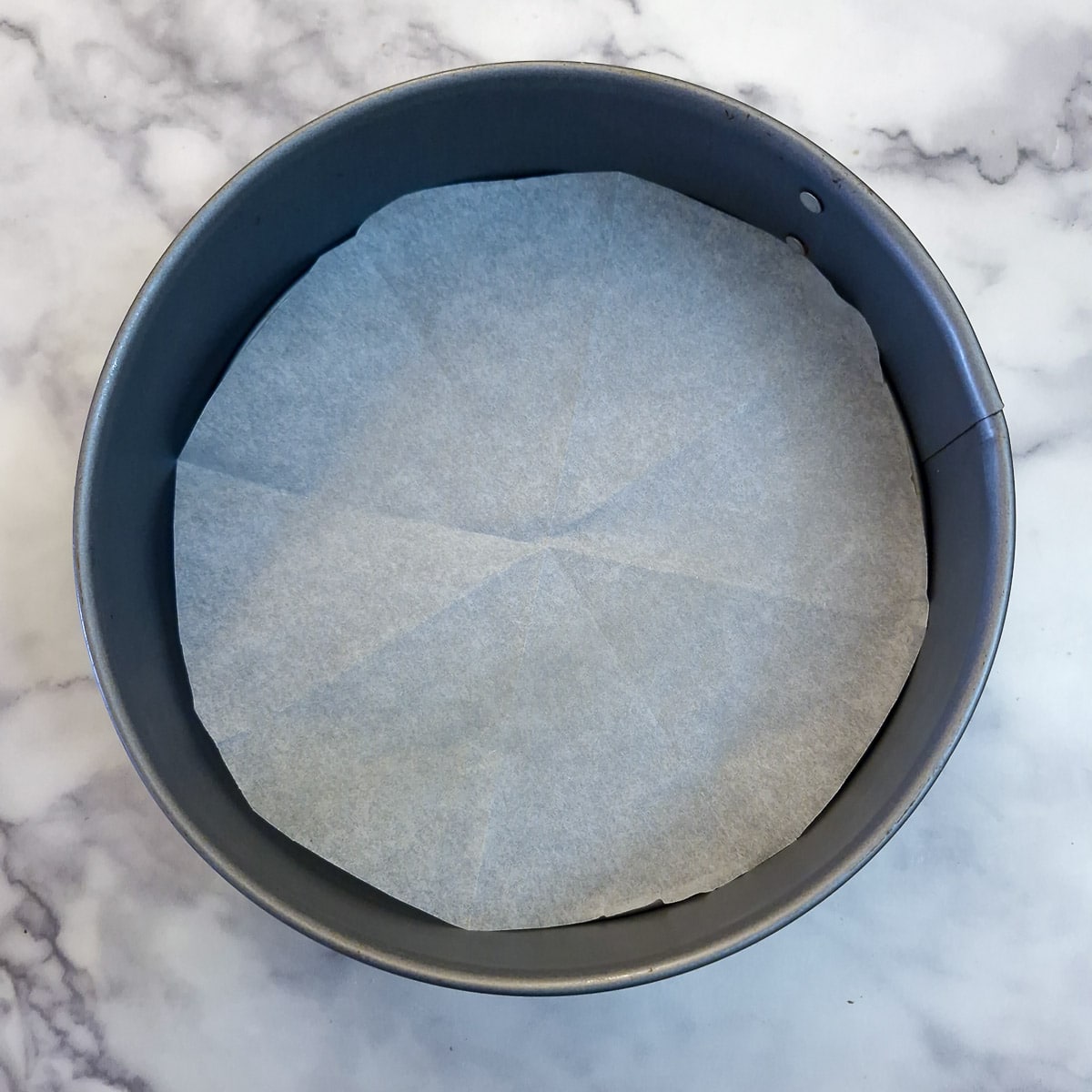 A springform pan lined with baking parchment.