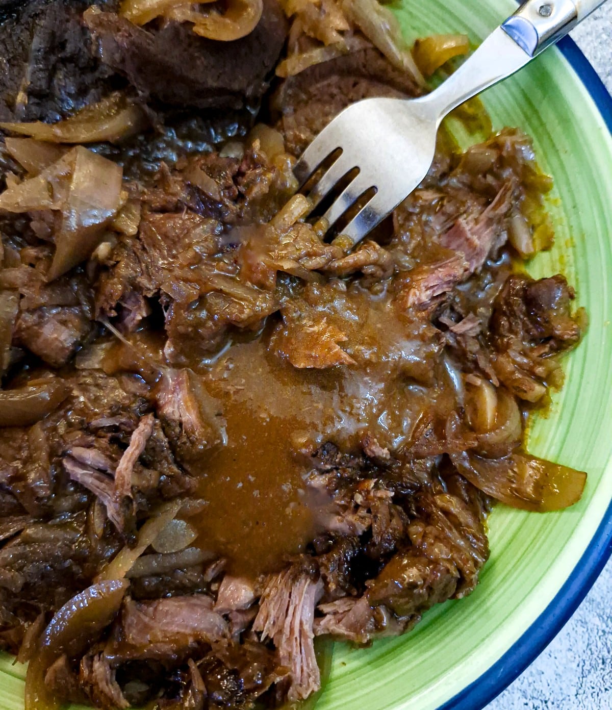Sloow cooked featherblade steak being pulled apart with a fork.