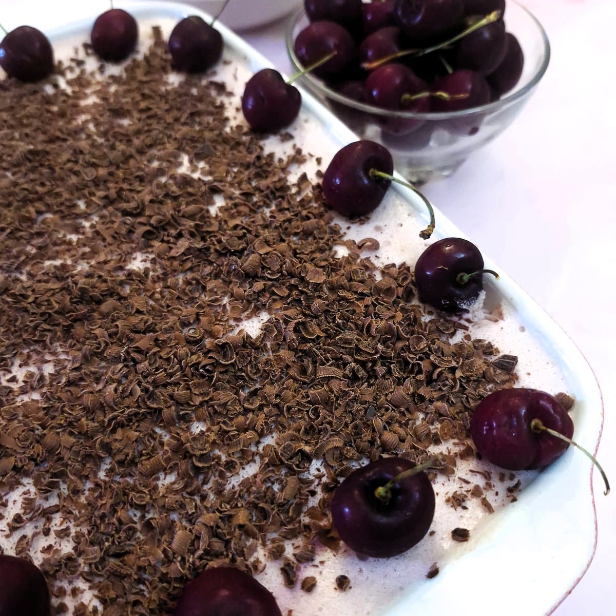 Cl;ose up of the cherry fridge tart, showing the chocolate shavings with cherries around the edge of the dish.