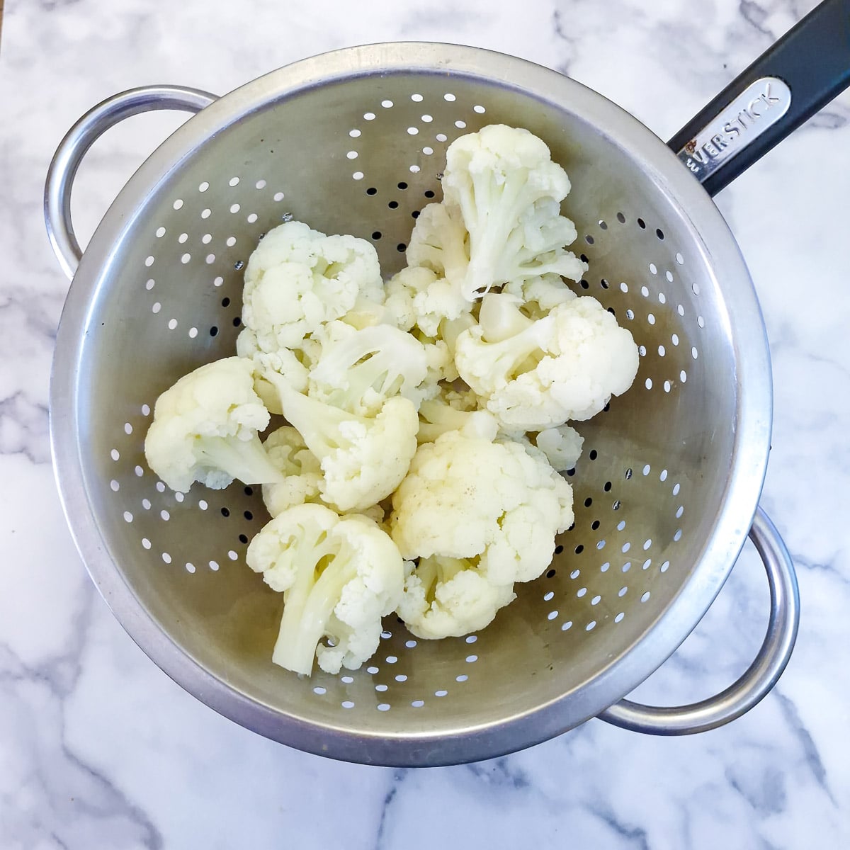 Step 2 - cauliflower florets draining in a colander.