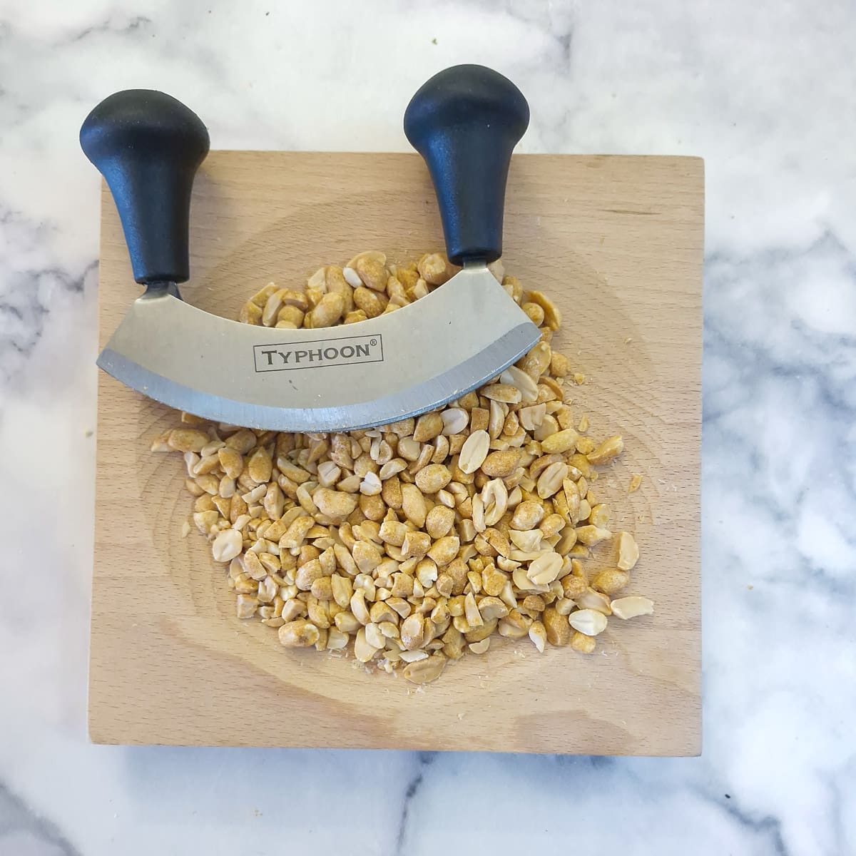 Step 1 - peanuts being chopped with a mezzaluna.