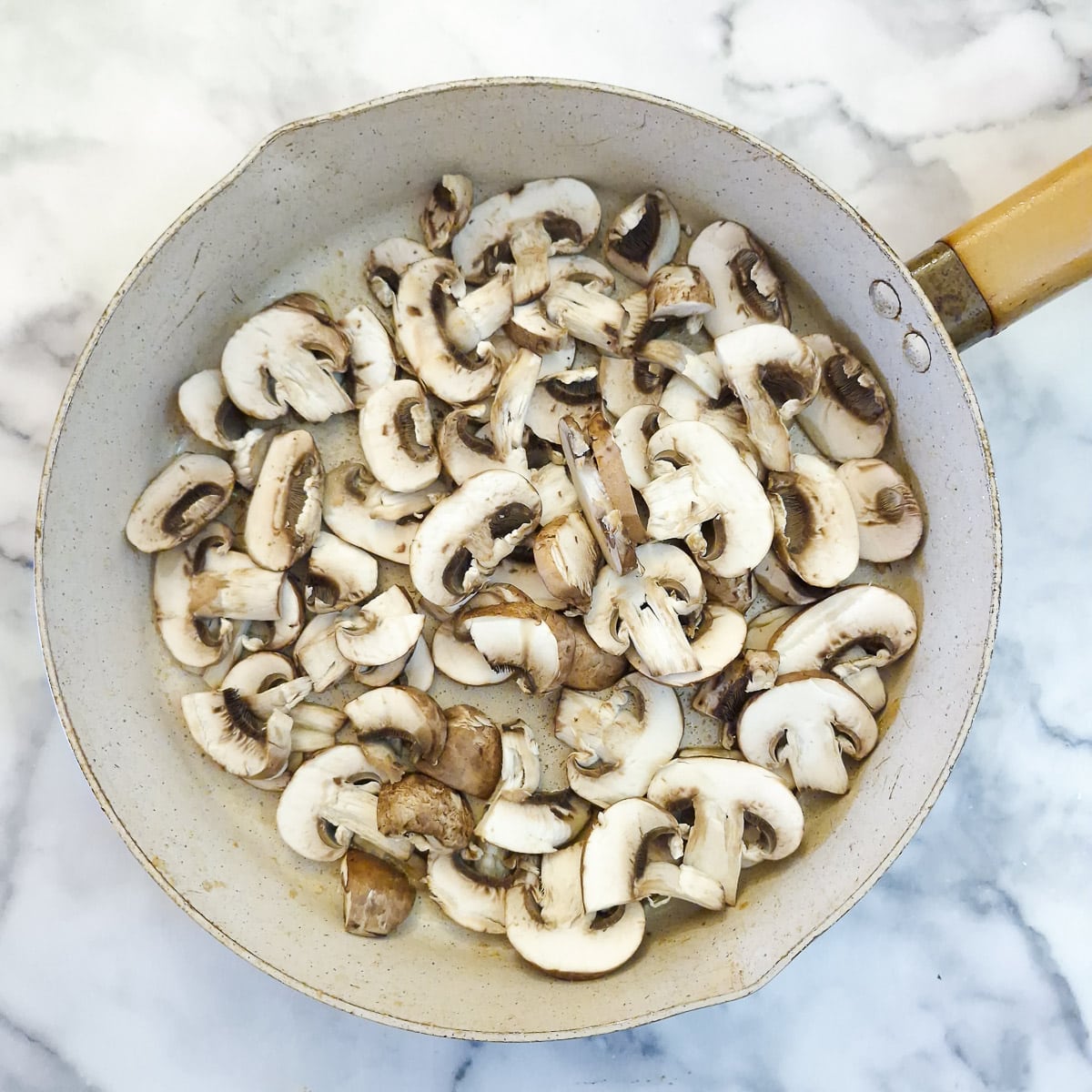 Step 3 - raw mushrooms in a frying pan.