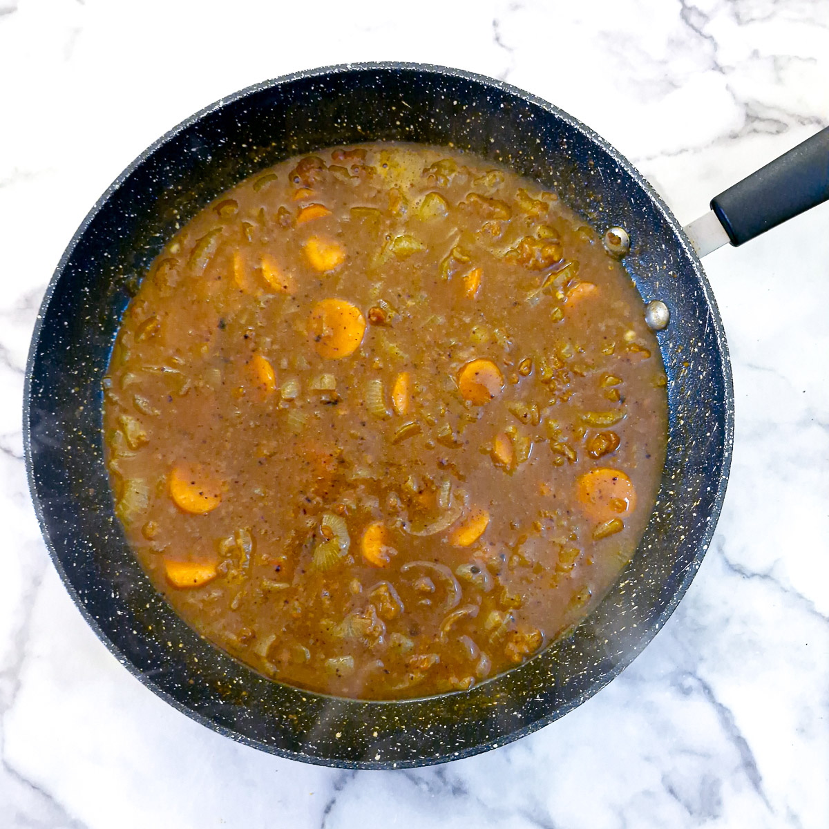 Step 6 - Stock and sliced carrots added to the onions.