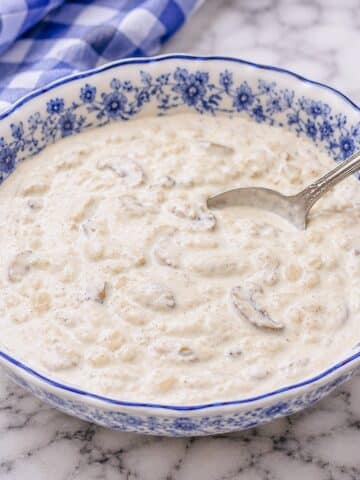 A blue-patterned dish filled with creamy mushroom and onion sauce.