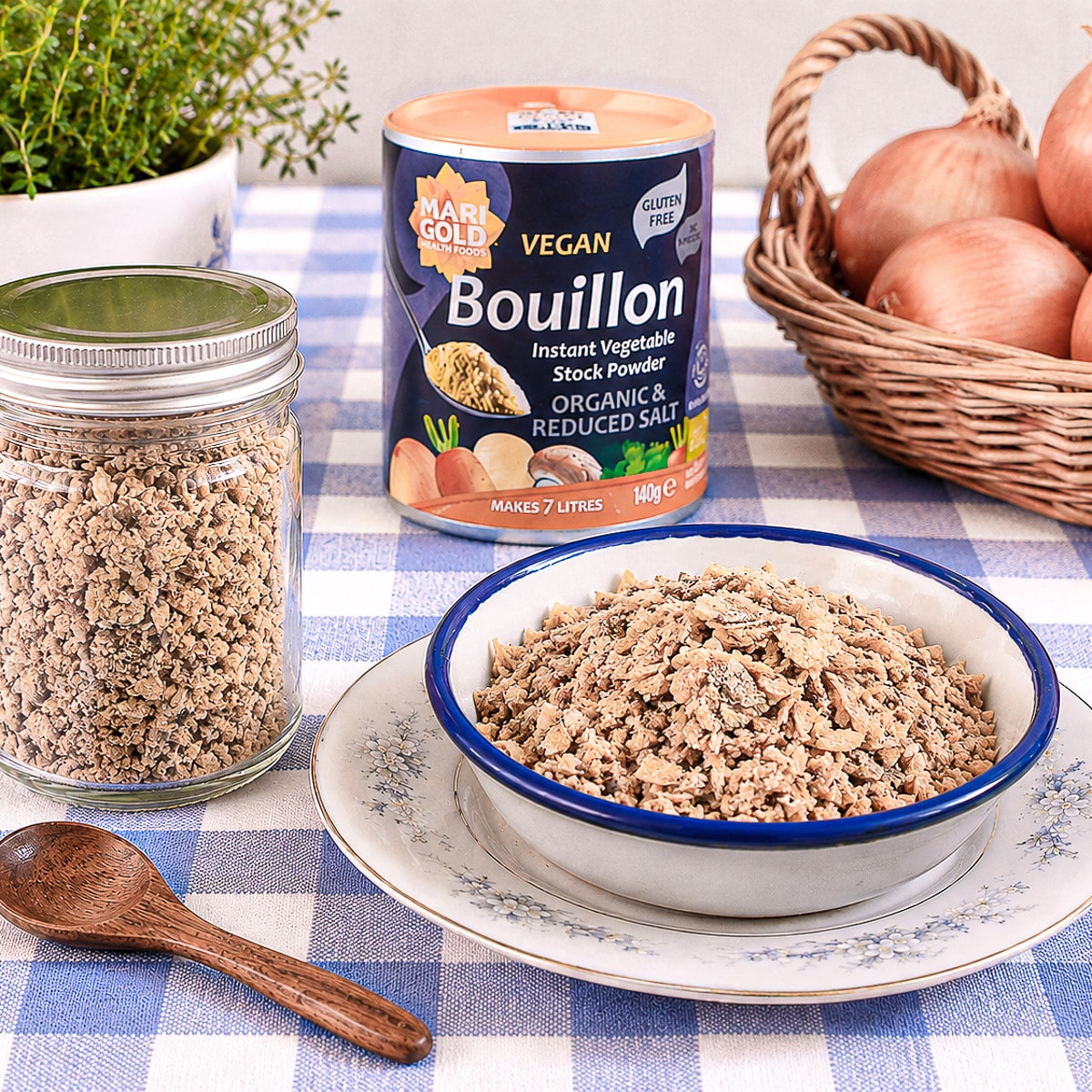 A small dish of French onion soup mix next to a screw top jar containing the rest of the mis.