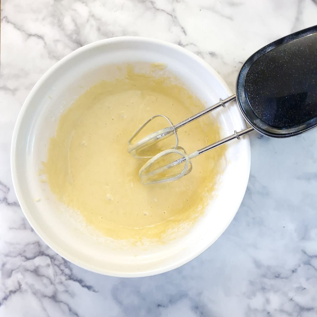 Step 2 - spaetzle batter being whisked with an electric hand mixer.