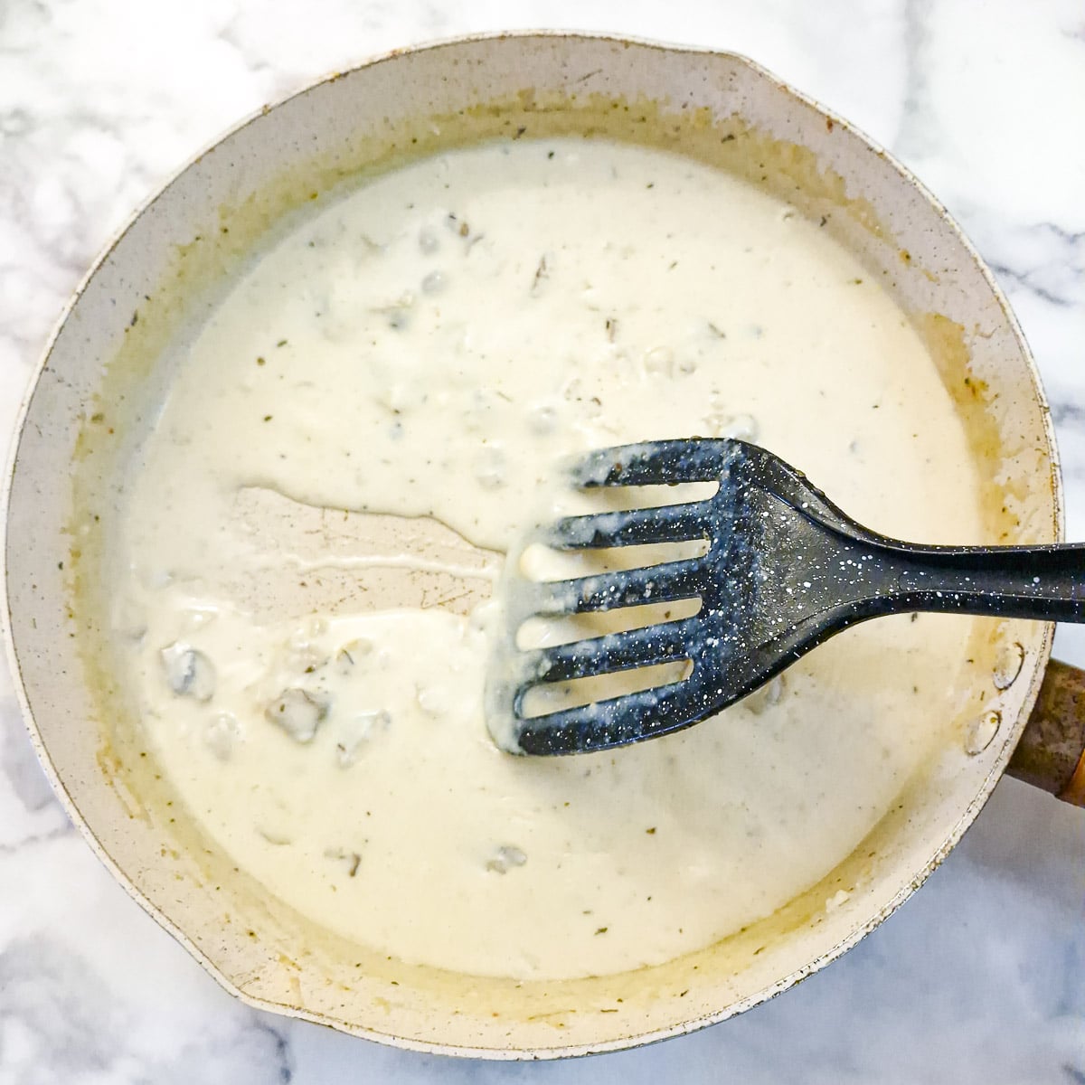 Step 5 - A spatula being drawn through a pan of mushroom sauce showing how it leaves a trail.