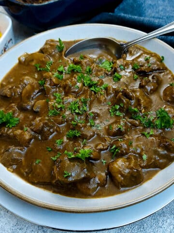 A dish of braised shin beef and onions in a rich horseradish gravy.