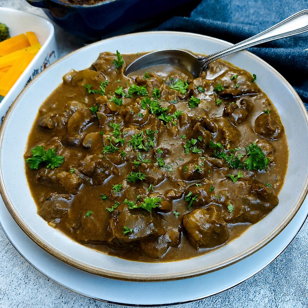 A dish of braised shin beef and onions in a rich horseradish gravy.