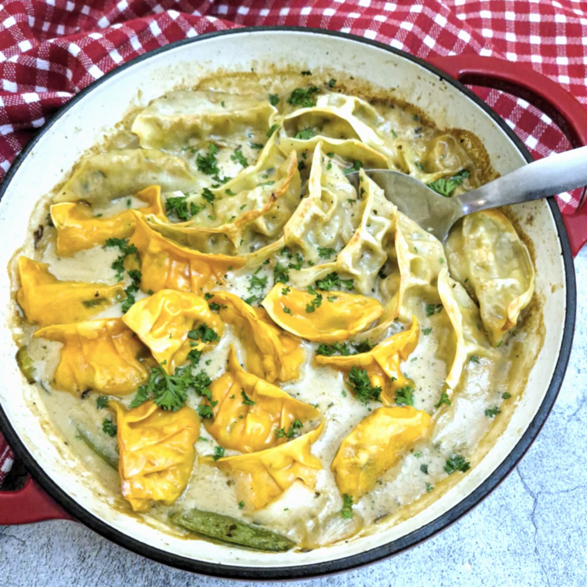 A red casserole dish filled with Thai green curry gyoza bake.