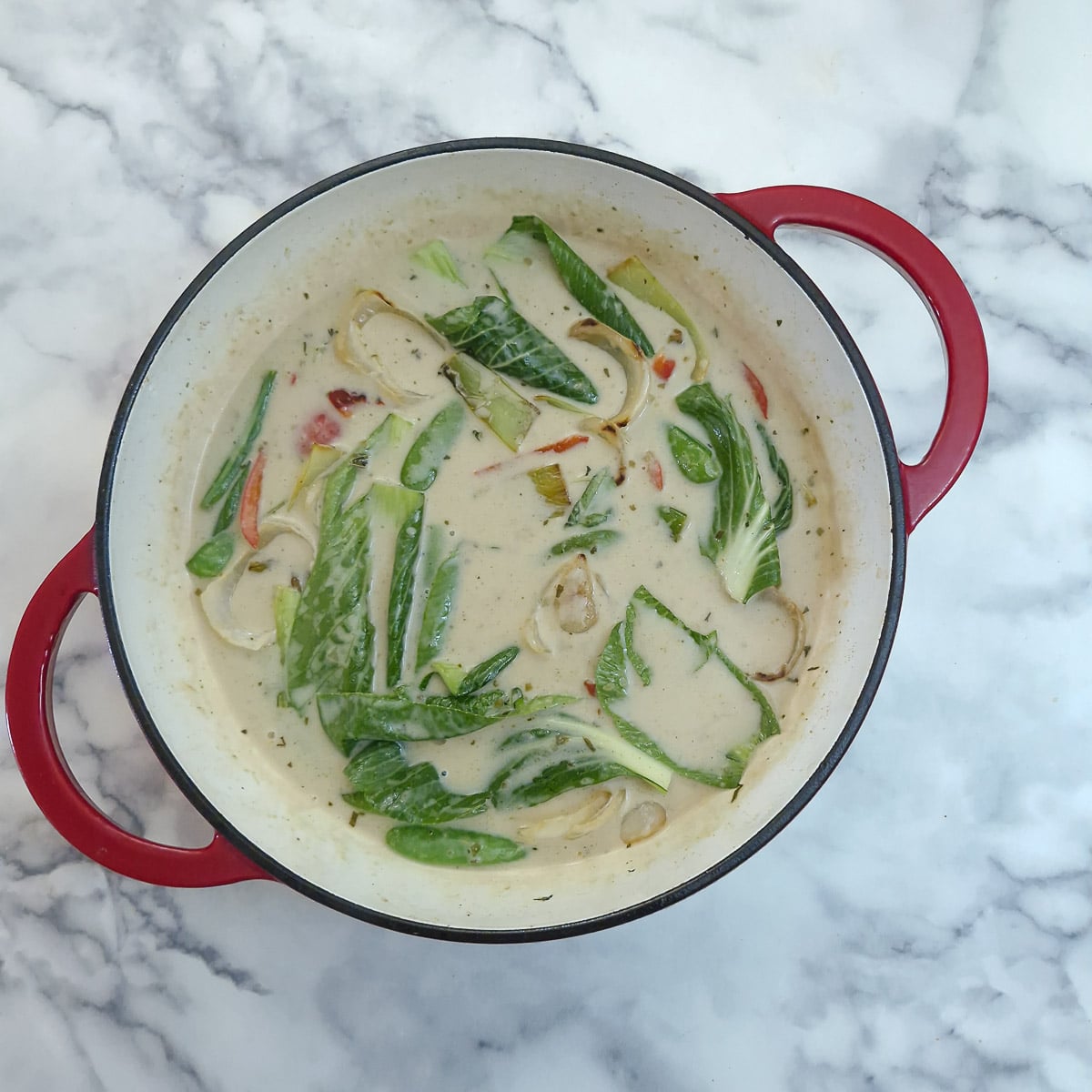 Step 5 - softened vegetables and pak choi leaves added back to the pan.
