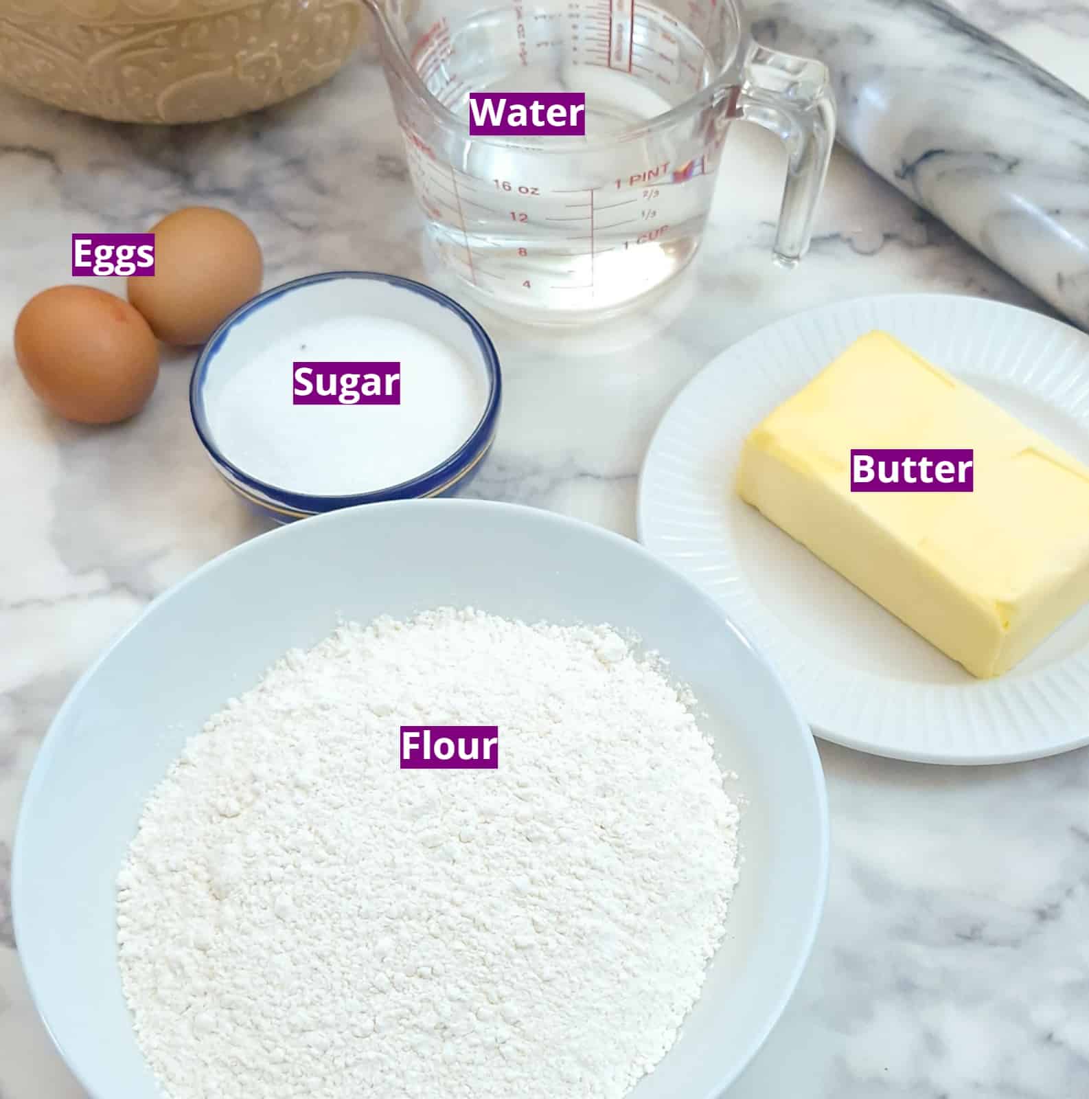 Basic ingredients for making pastry - flour, butter and water. There is a dish of sugar and 2 eggs close by as these can be used to enrich and sweeten the basic pastry.