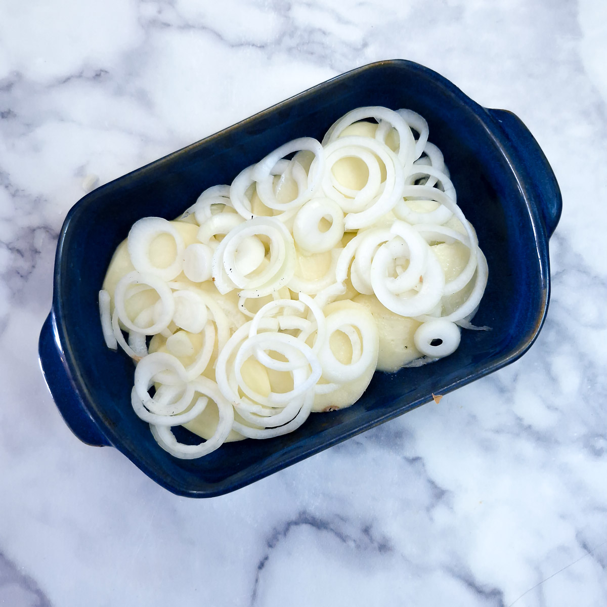 Step 2 - Sliced onions arranged on top of potatoes.