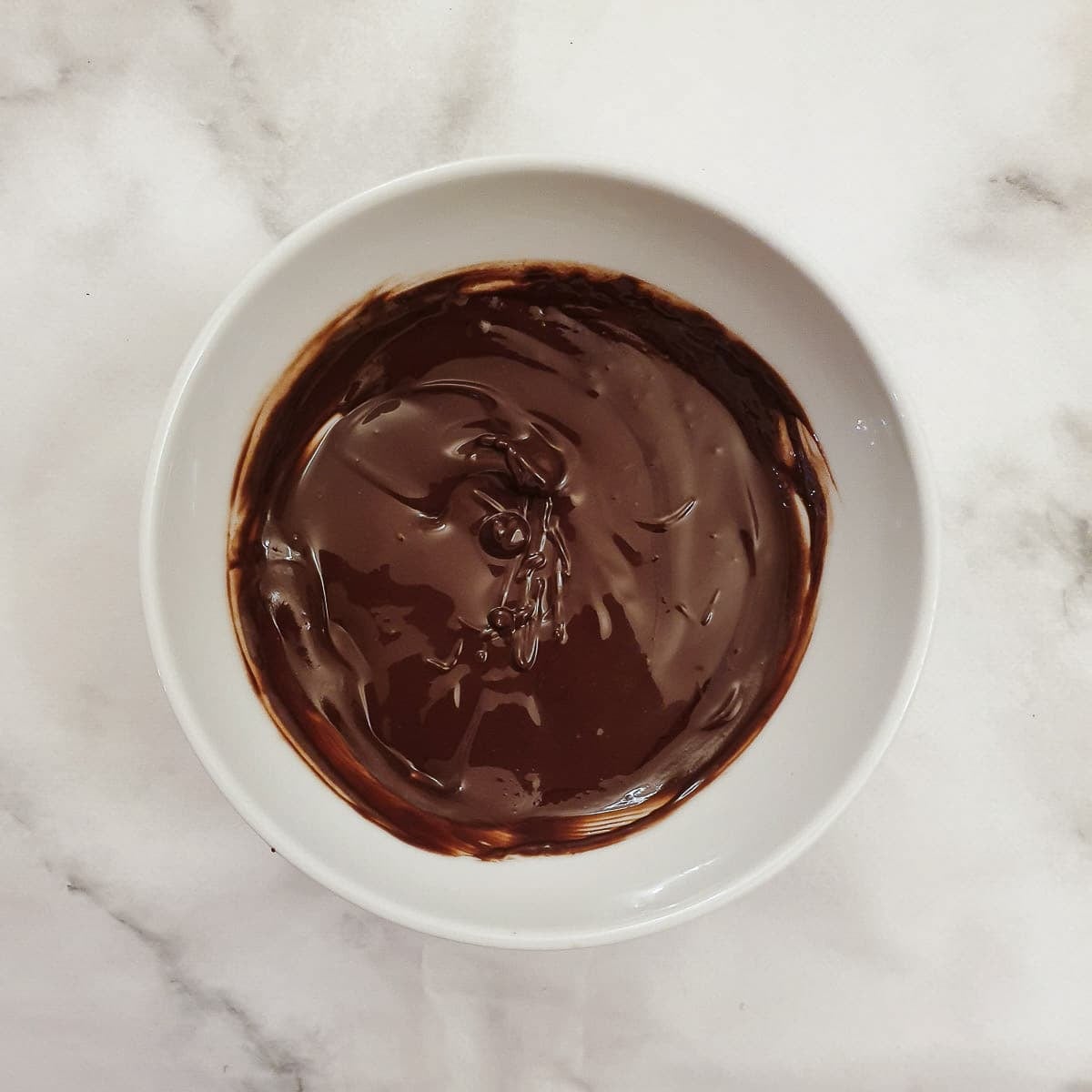 Step 2 - melted chocolate in a small white bowl.