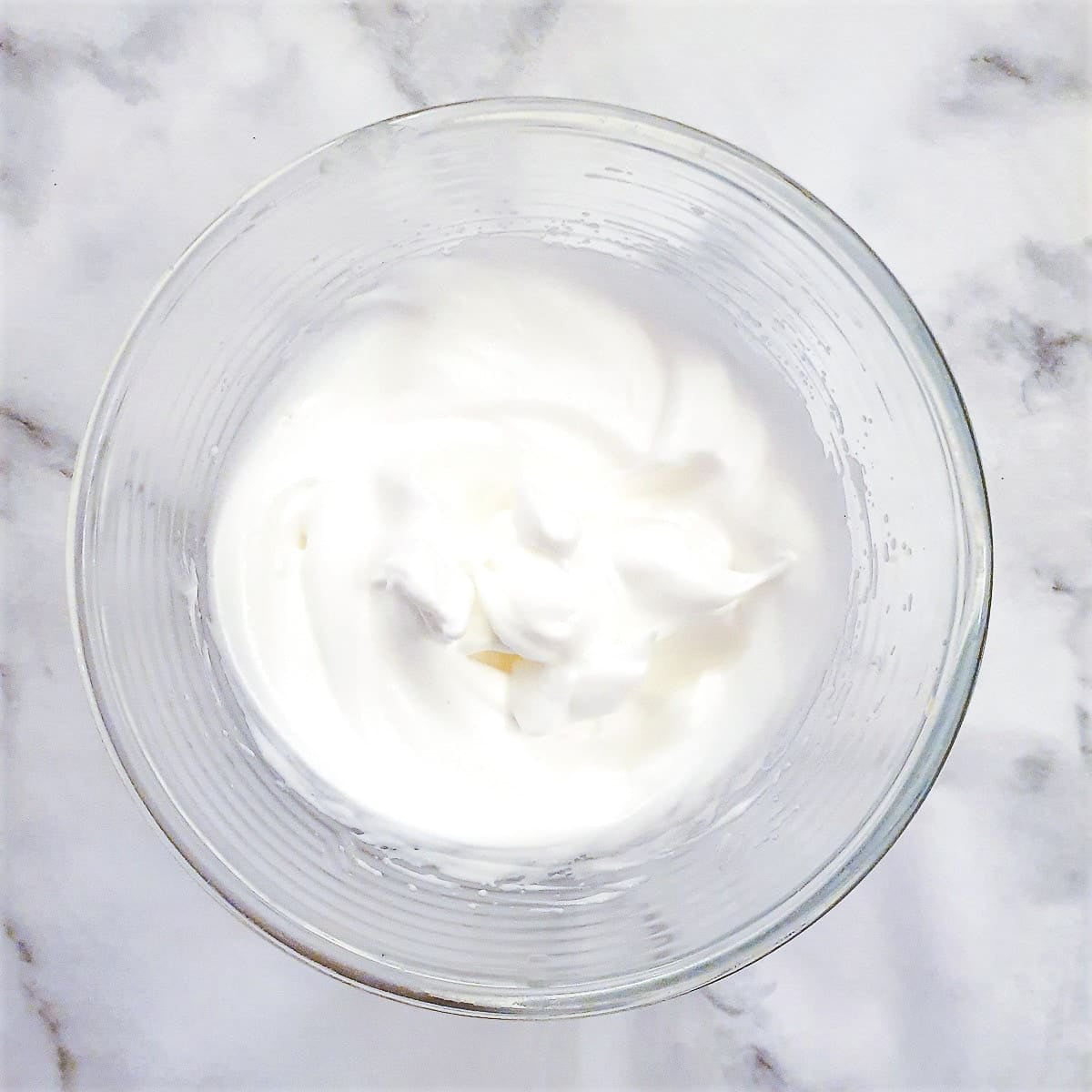 Step 4 - Egg whites whipped to stiff peaks in a glass bowl.