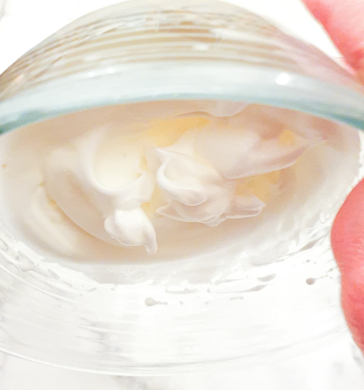 Step 5 - Stiffly beaten egg white in a bowl being turned upside down, showing how they don't fall out of the bowl.