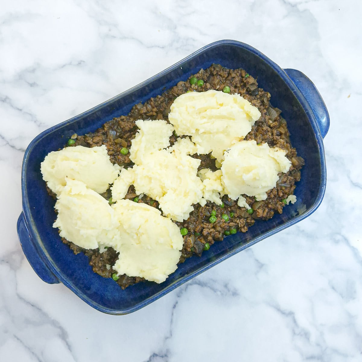 Step 10 - spoonfuls of mashed potato on top of the mince.