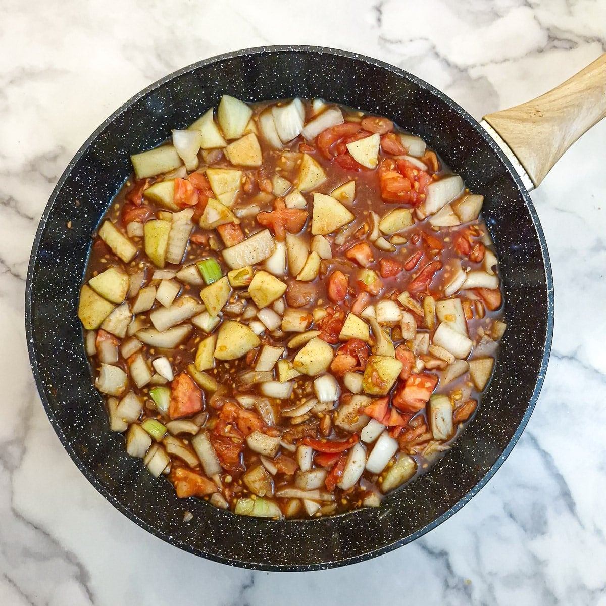 Step 2 - tomato chutney being brought to a boil in a large wok.