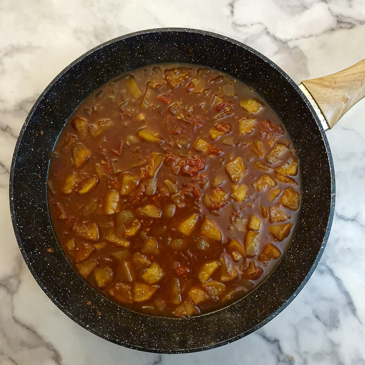 Step 3 - tomato chutney simmering, uncovered, in a wok.